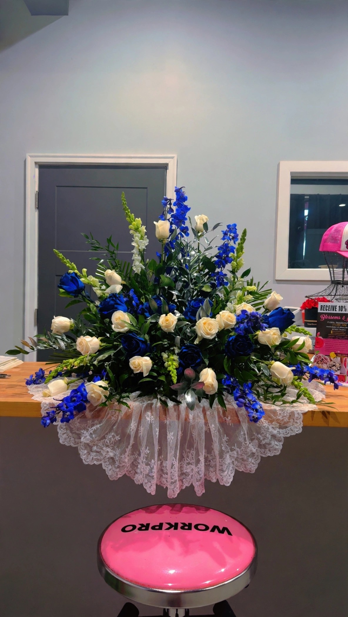 Blue and white urn arrangement with roses, pictured in the Blossoms & Gems shop